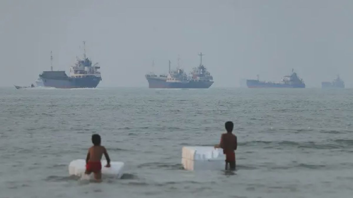 Dua Bocah Bermain di Perairan Dangkal Bandar Abbas, Kapal Tanker Melintas